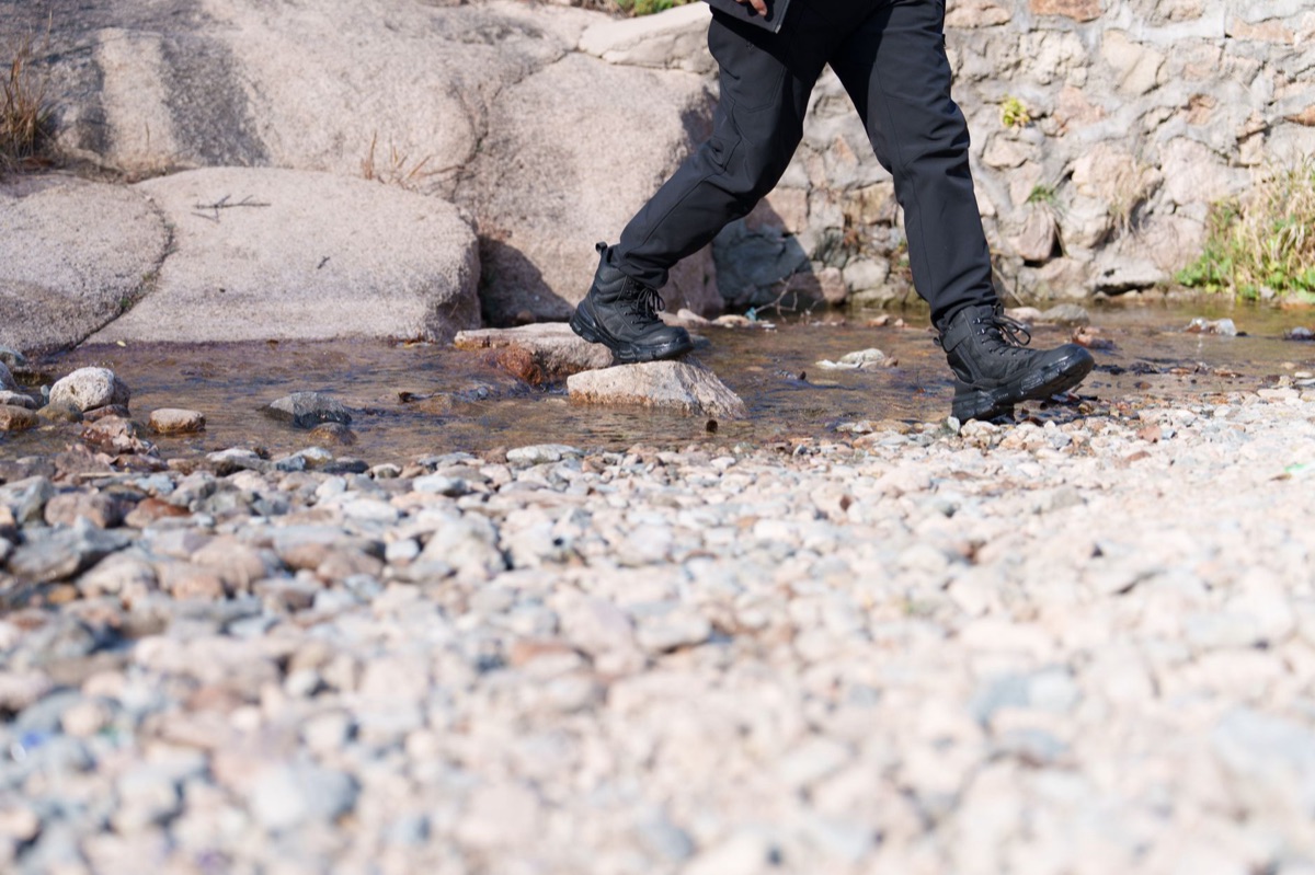 Hiking boots on rocky path along the 4-country Alps route