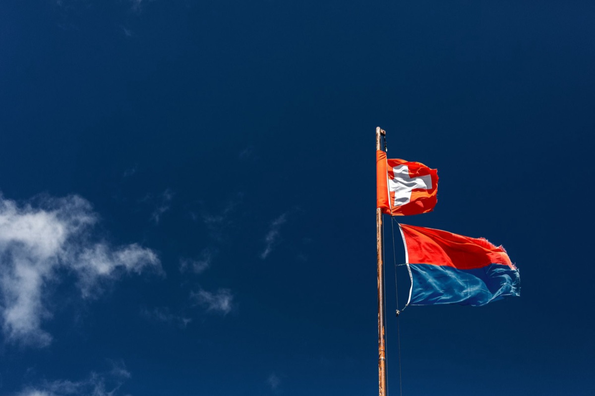 Alpine summit with four country flags marking the 4-country Alps route