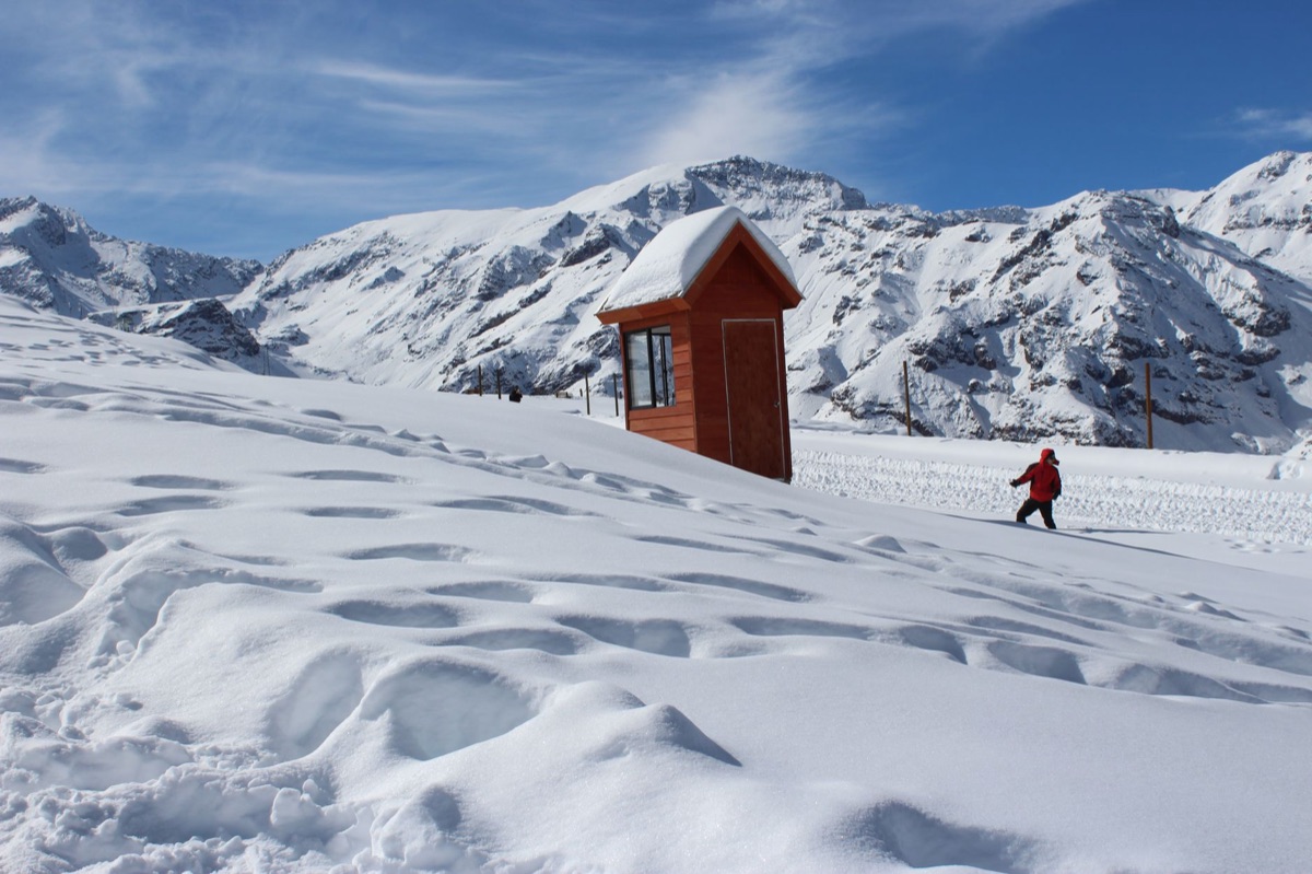 Sneeuwige berg met een eenvoudige hut in de verte