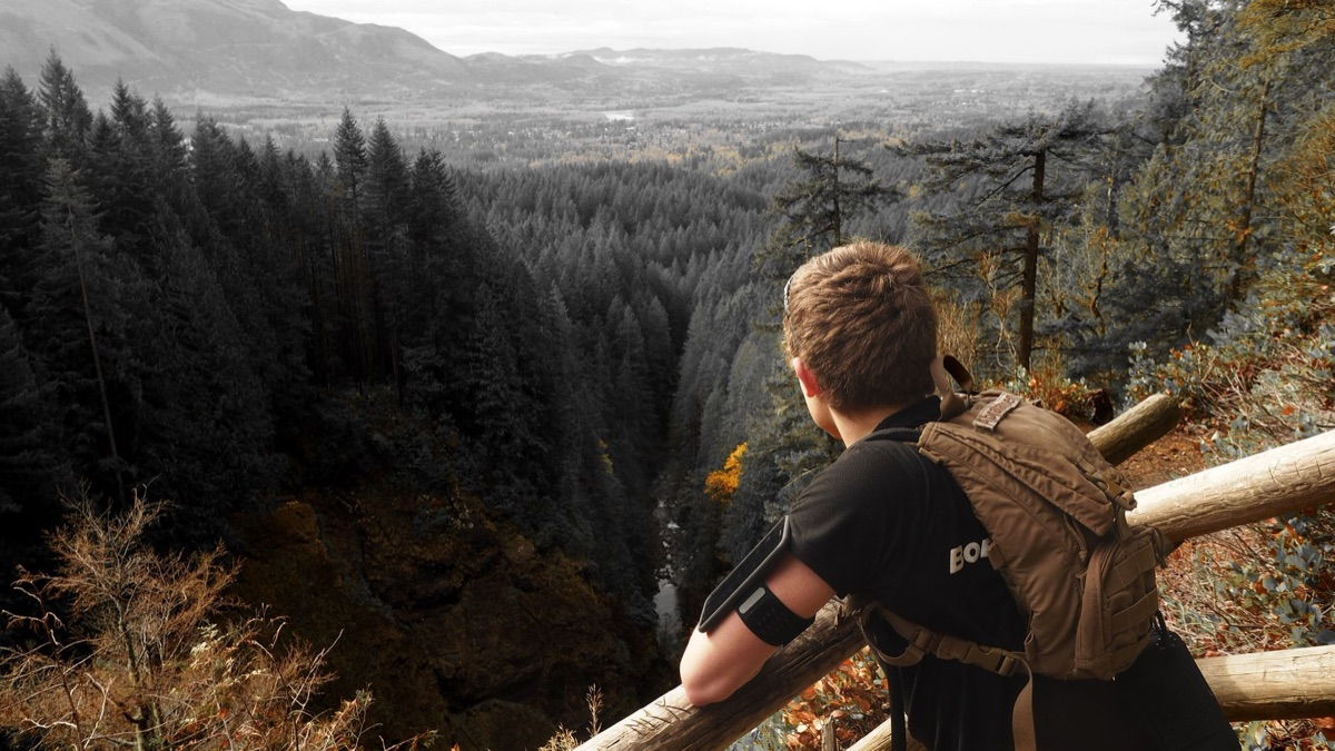 Hiker on mountain path with scenic overlook