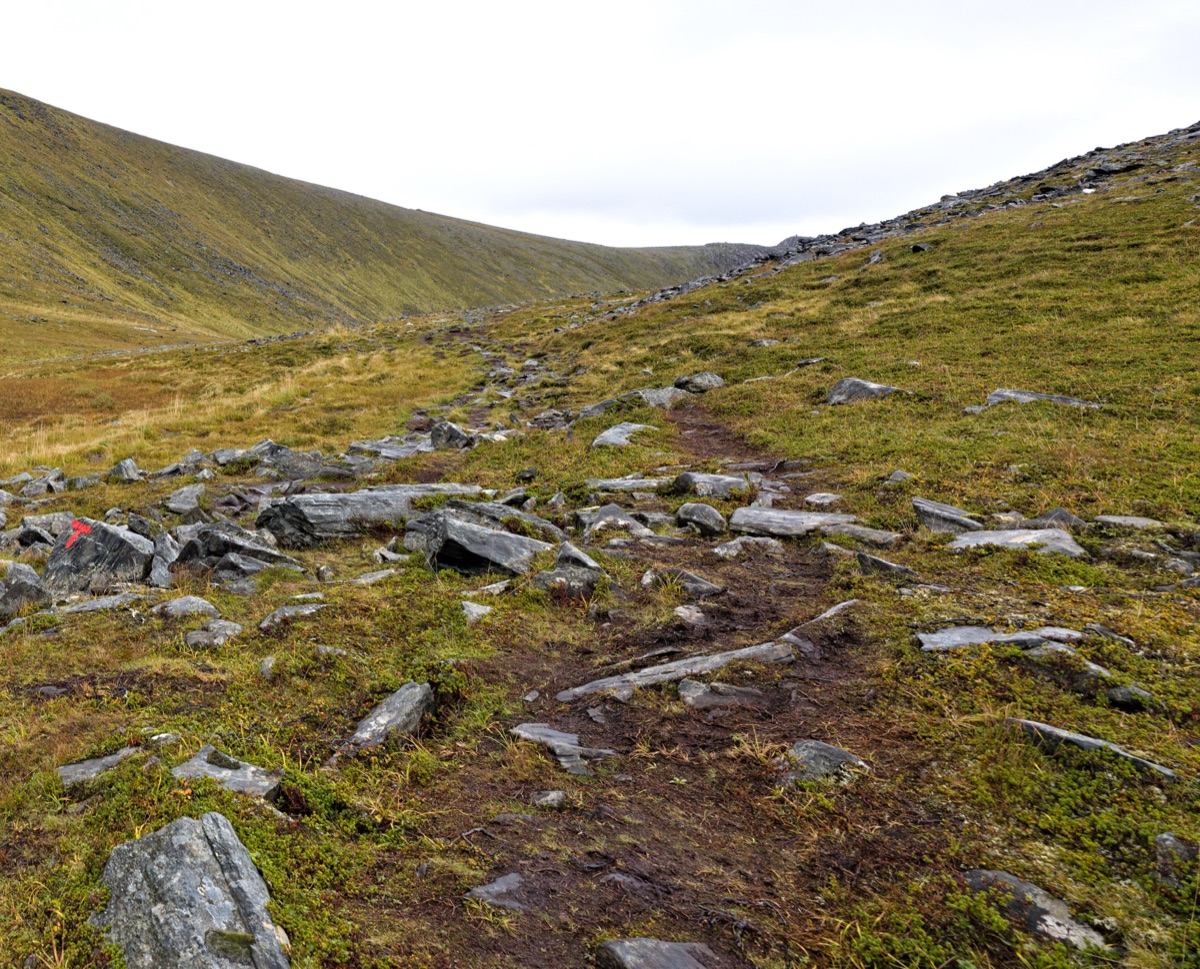 Hiking trail markers with elevation signs and time indicators