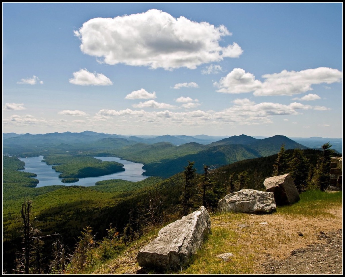 Alpine summit view with panoramic mountain range and hiking trail markers