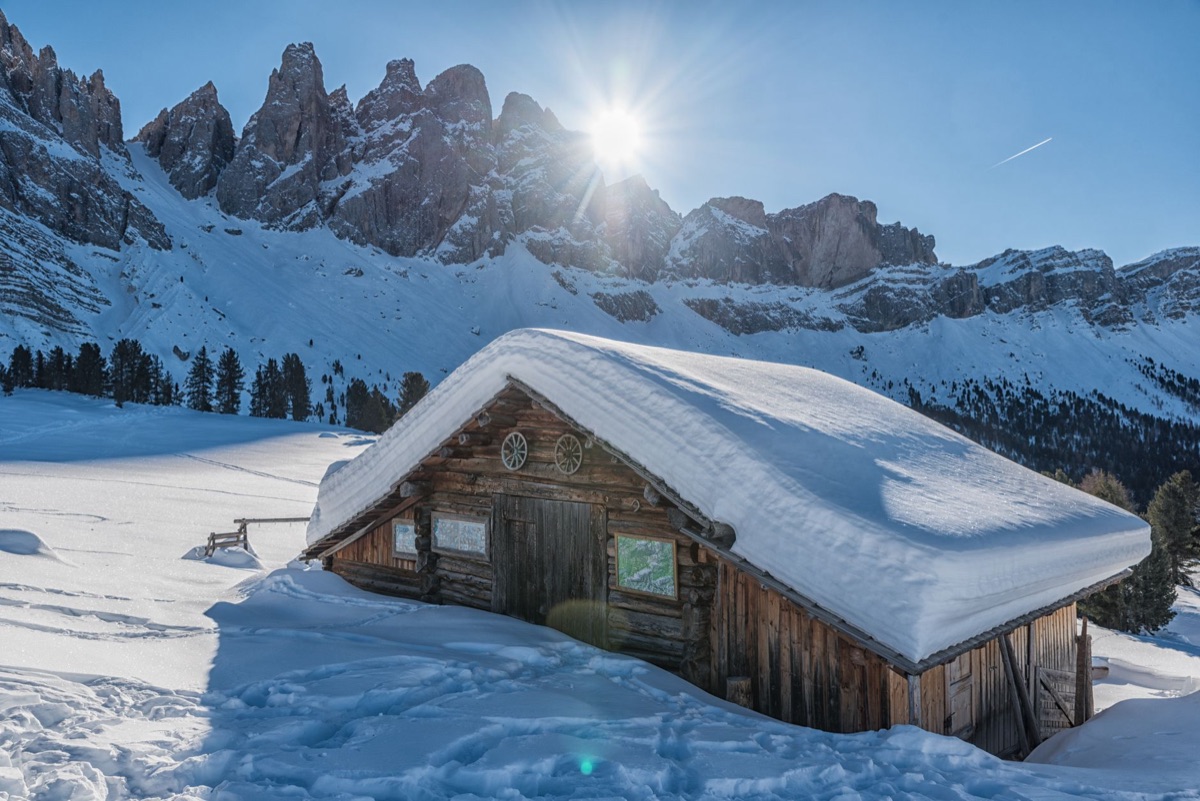 Alpine hütte with snow-covered mountain in background