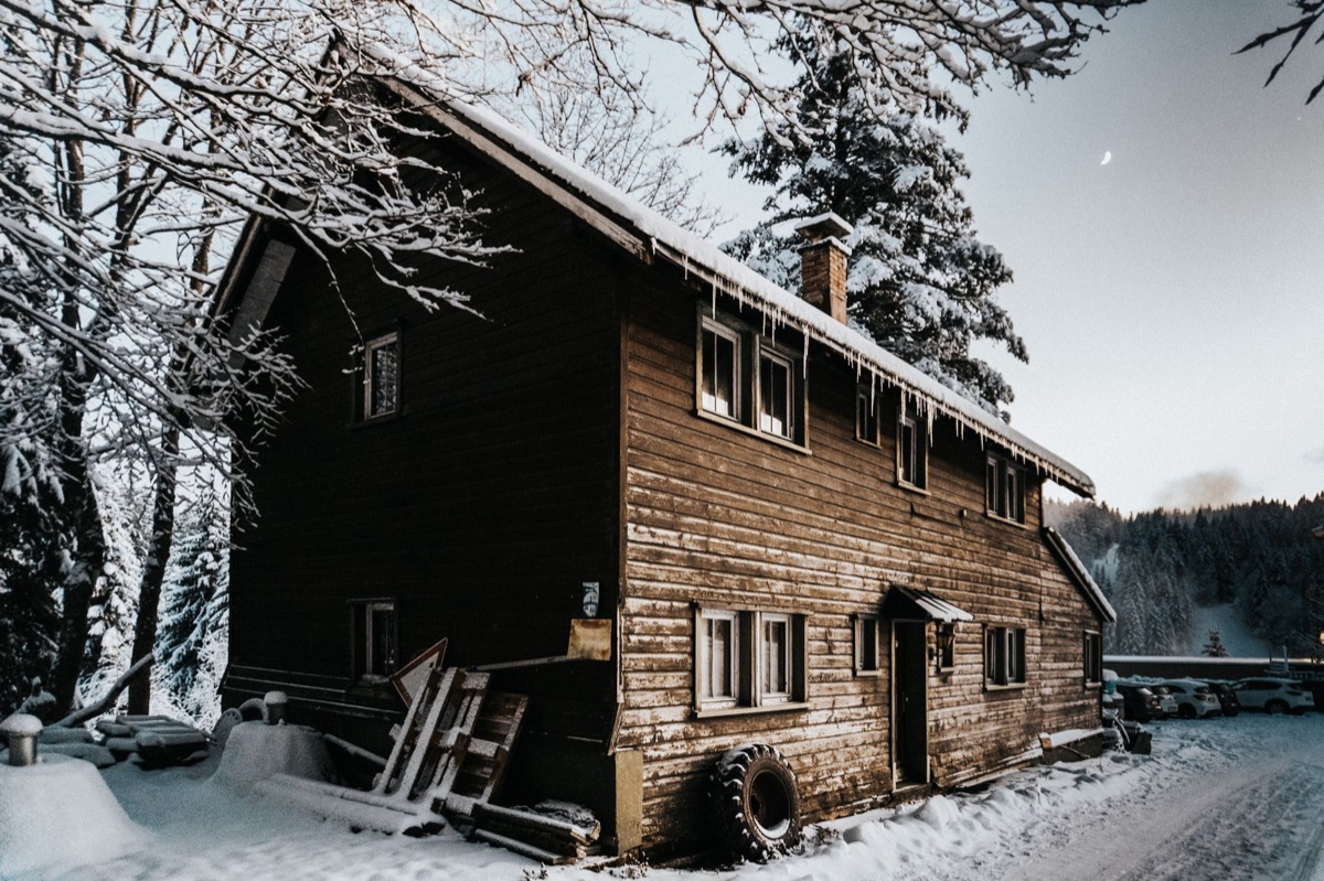 Porta di una hütte in legno con neve intorno